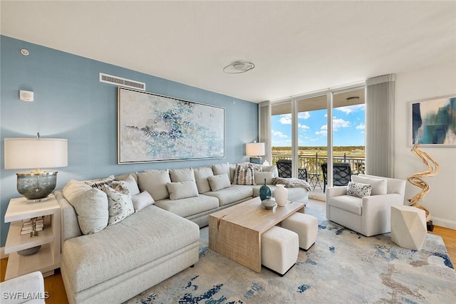 living room with floor to ceiling windows and light wood-type flooring