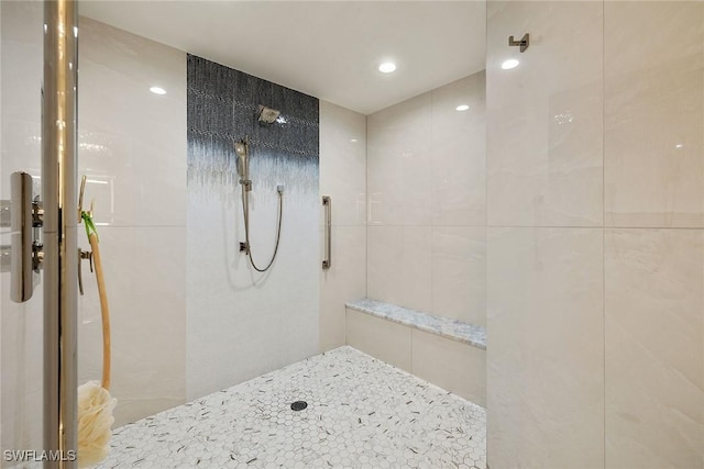 bathroom with tile walls and tiled shower