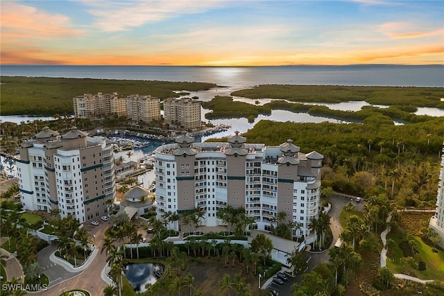 aerial view at dusk featuring a water view