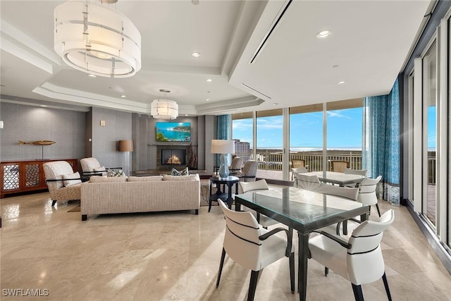 dining space with a tray ceiling and a wall of windows