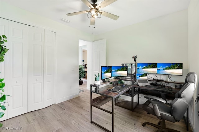 office space with ceiling fan, baseboards, visible vents, and light wood-style floors