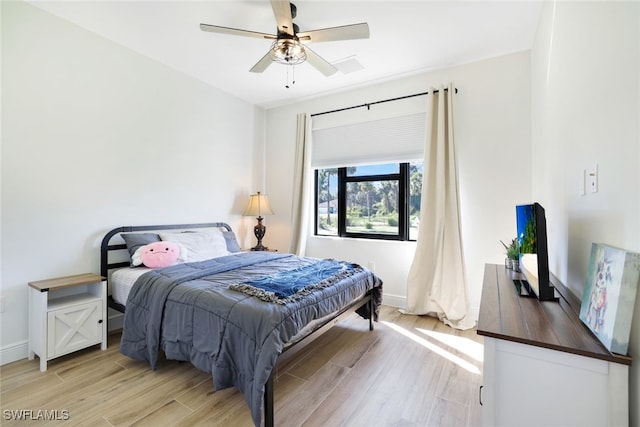 bedroom featuring ceiling fan, light wood-type flooring, and baseboards