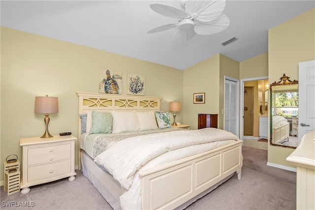 carpeted bedroom featuring ceiling fan, vaulted ceiling, ensuite bathroom, and a closet