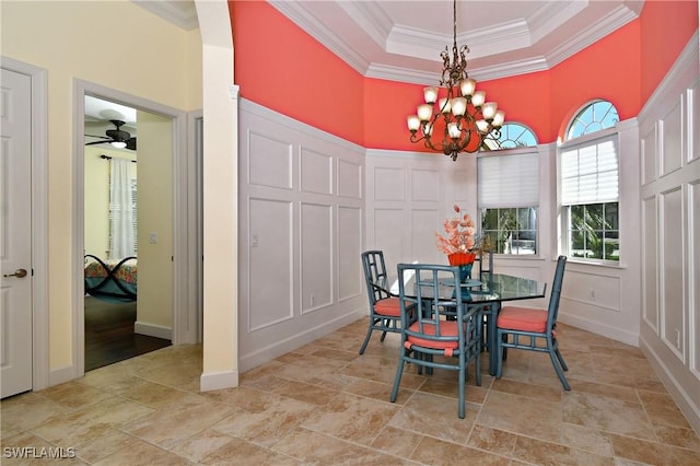 dining space with a towering ceiling, ceiling fan with notable chandelier, and ornamental molding