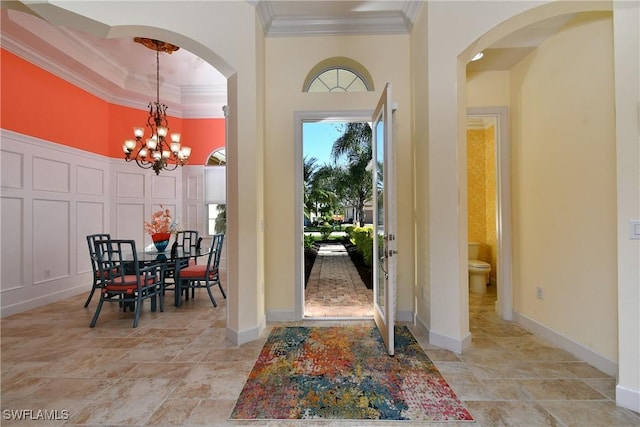 entryway featuring crown molding and a chandelier