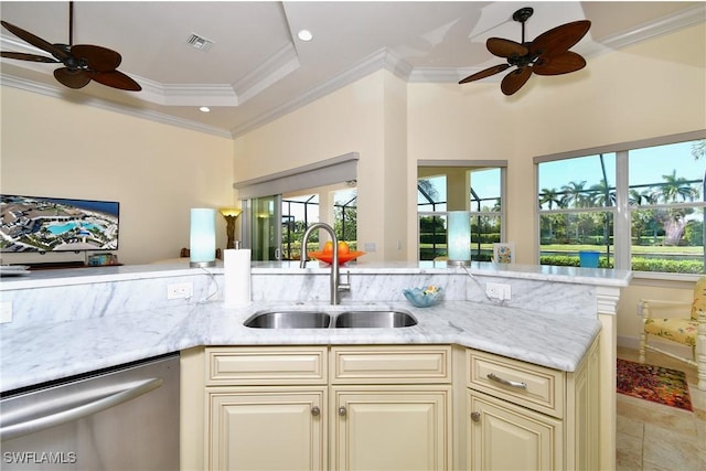 kitchen featuring dishwasher, sink, light stone counters, cream cabinetry, and ornamental molding