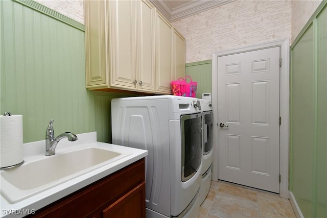 clothes washing area with sink, cabinets, crown molding, and washing machine and clothes dryer