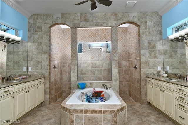 bathroom with tiled bath, a healthy amount of sunlight, and tile walls