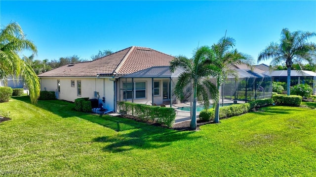 back of house with a lanai and a yard