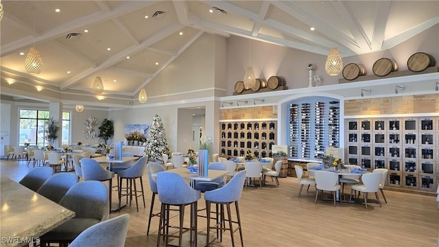 interior space with beam ceiling, high vaulted ceiling, and light hardwood / wood-style floors