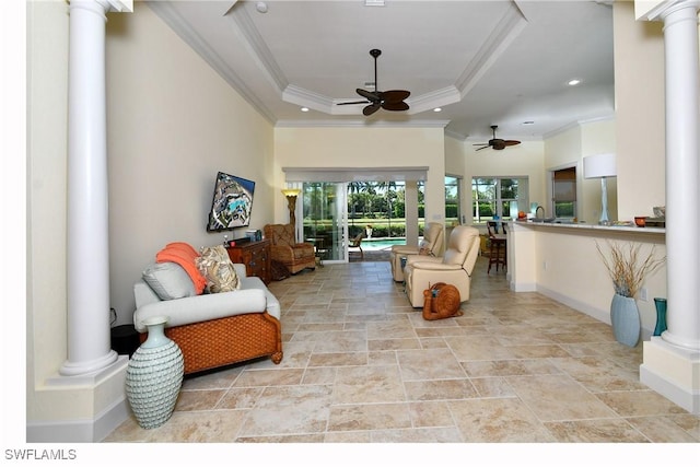 living room with ceiling fan, a raised ceiling, and crown molding