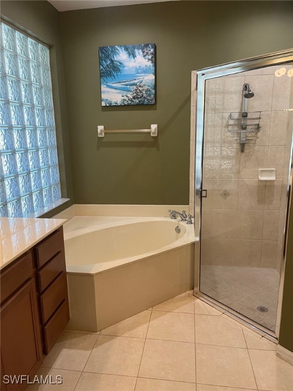 bathroom with tile patterned flooring, vanity, and shower with separate bathtub