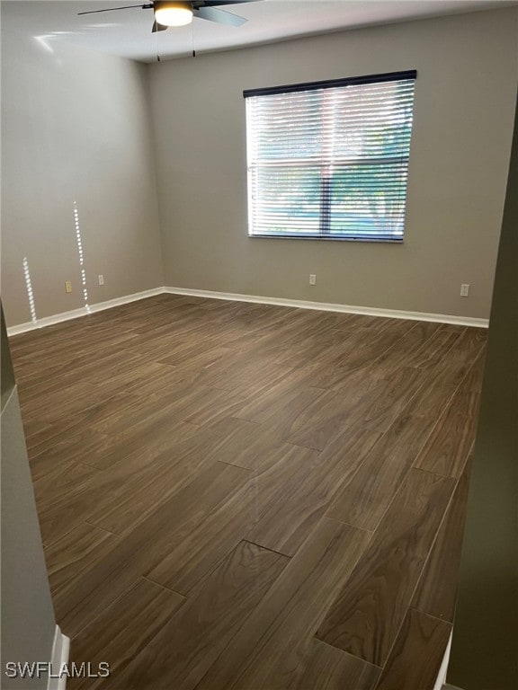 empty room with ceiling fan and dark hardwood / wood-style flooring