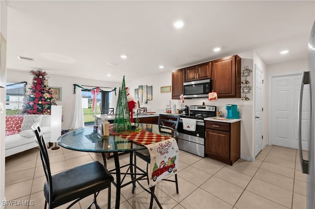 kitchen with light tile patterned flooring and appliances with stainless steel finishes