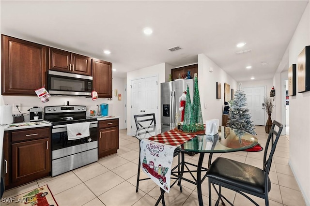 7024 Waldo Cir, Labelle, FL 33935 - kitchen featuring appliances with stainless steel finishes, light tile patterned floors, light countertops, recessed lighting, and dark brown cabinets