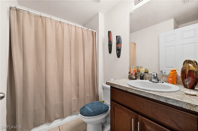 bathroom with toilet, vanity, and tile patterned floors