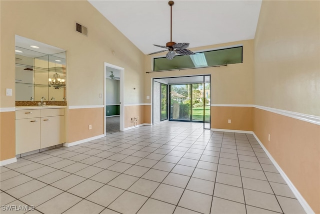 empty room with ceiling fan, light tile patterned floors, and lofted ceiling