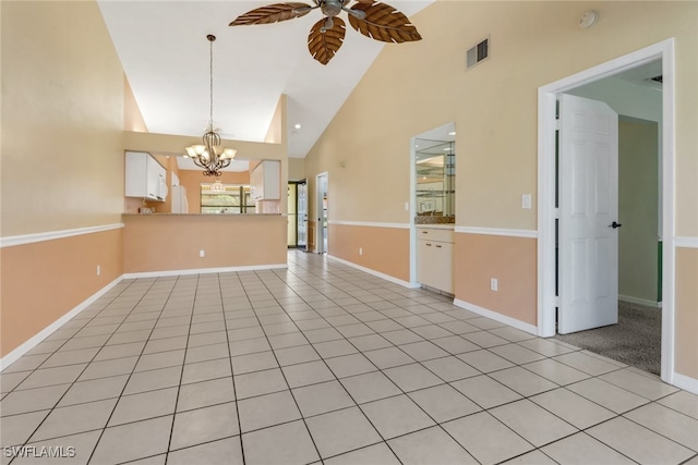 unfurnished living room with light tile patterned floors, ceiling fan with notable chandelier, and high vaulted ceiling