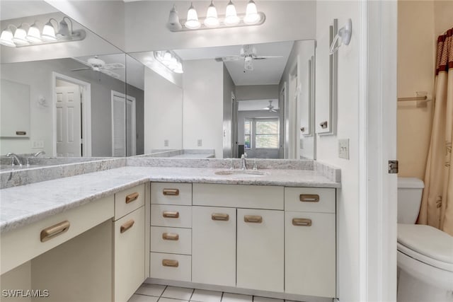 bathroom with toilet, vanity, tile patterned flooring, and ceiling fan