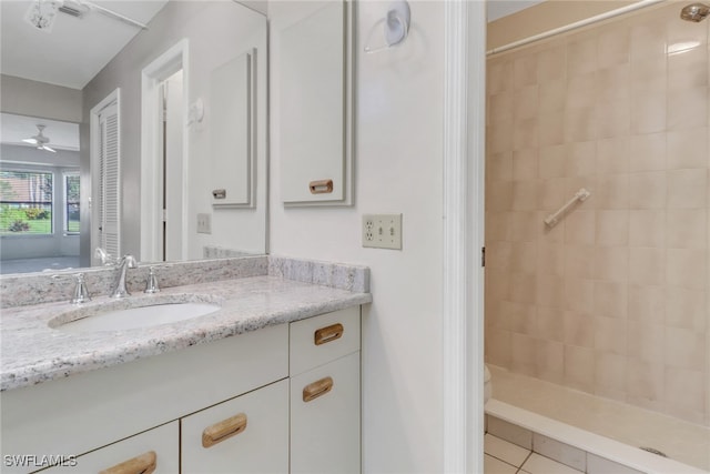 bathroom with ceiling fan, vanity, tile patterned flooring, and tiled shower