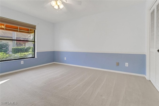 spare room with ceiling fan and light colored carpet