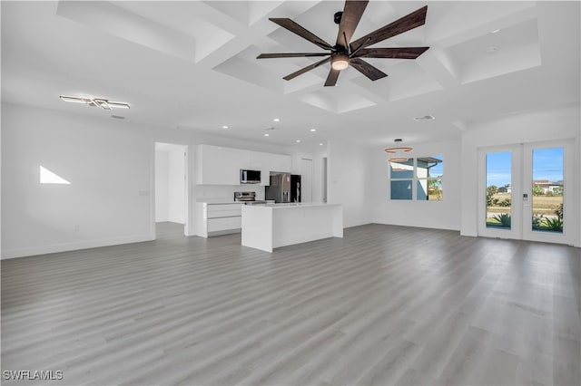 unfurnished living room featuring ceiling fan, light hardwood / wood-style flooring, beamed ceiling, and coffered ceiling