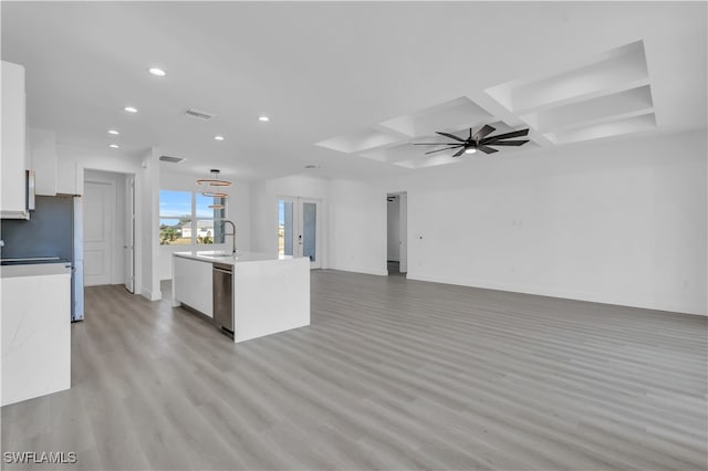 kitchen with white cabinets, light wood-type flooring, a center island with sink, and ceiling fan