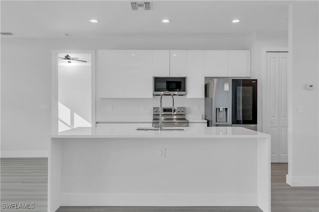 kitchen featuring stainless steel appliances, ceiling fan, sink, light hardwood / wood-style flooring, and white cabinets