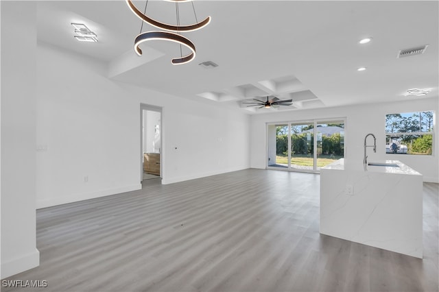 unfurnished living room with ceiling fan, sink, and light hardwood / wood-style floors