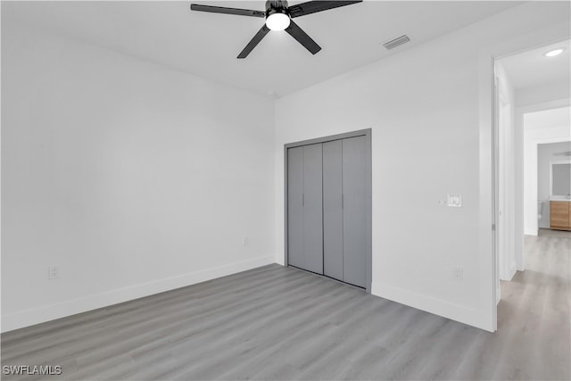 unfurnished bedroom with ceiling fan, a closet, and light hardwood / wood-style floors