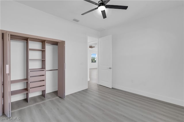 unfurnished bedroom with ceiling fan, light wood-type flooring, and a closet