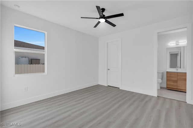 unfurnished bedroom with ceiling fan, light hardwood / wood-style floors, and connected bathroom