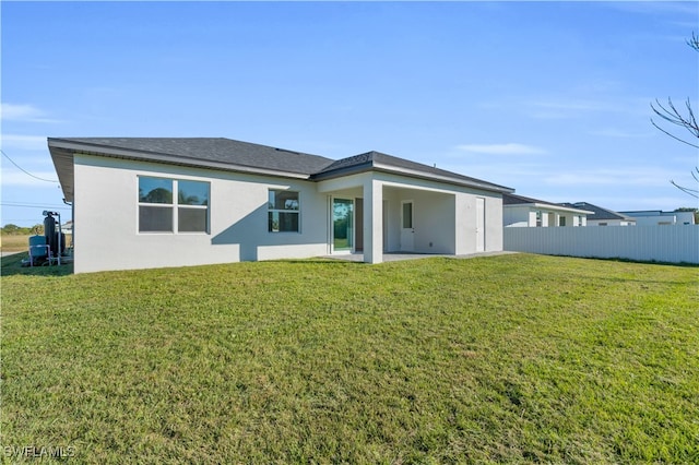 rear view of house featuring a lawn