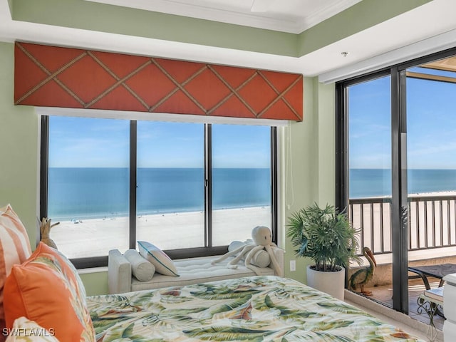 bedroom featuring a view of the beach, a water view, and crown molding