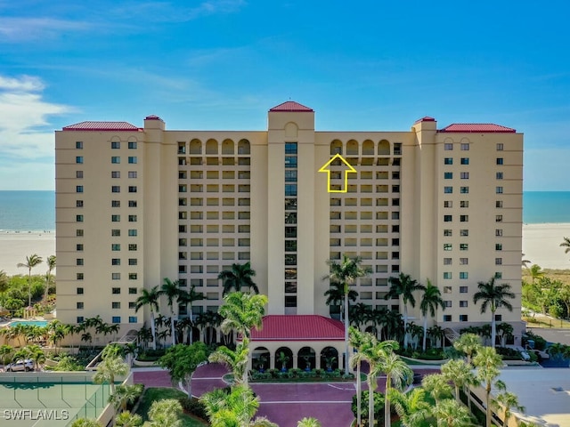 view of building exterior with a view of the beach and a water view