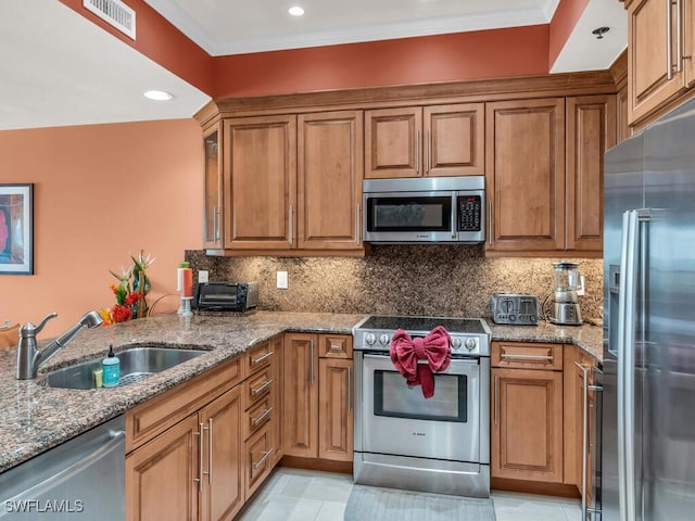 kitchen featuring backsplash, sink, light tile patterned floors, light stone countertops, and appliances with stainless steel finishes