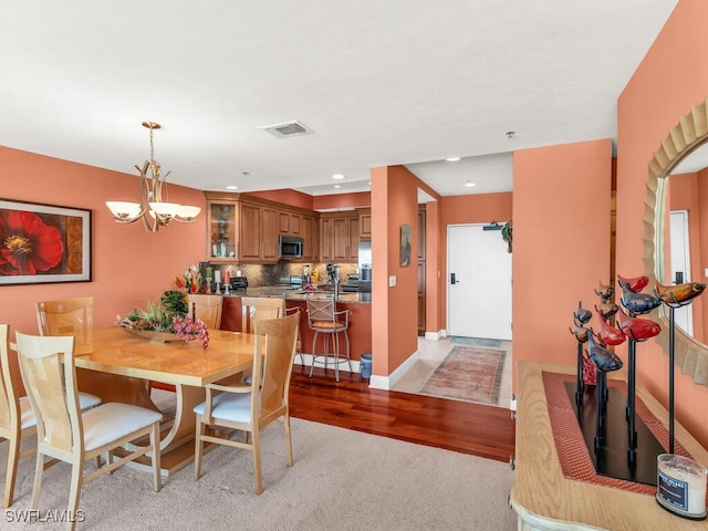 dining area featuring light hardwood / wood-style floors and a chandelier