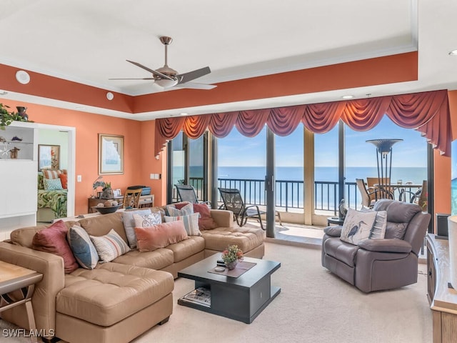 living room featuring carpet flooring, ceiling fan, crown molding, and a water view