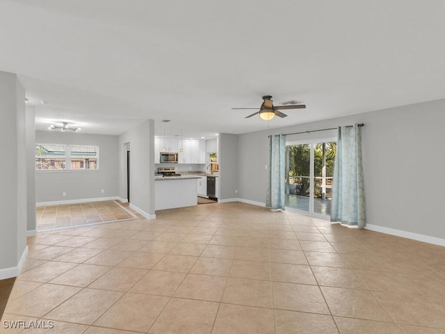 unfurnished living room with light tile patterned floors and ceiling fan