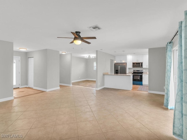 unfurnished living room featuring ceiling fan and light tile patterned flooring