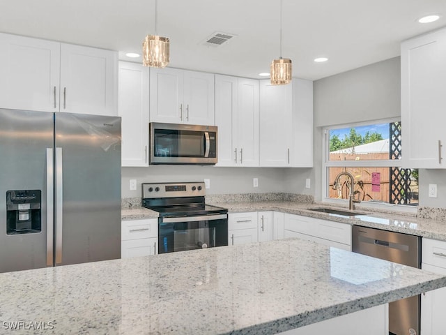 kitchen featuring white cabinetry, hanging light fixtures, stainless steel appliances, and sink