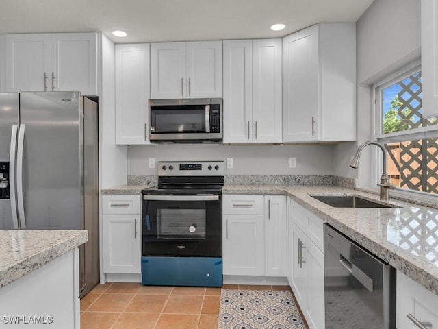 kitchen with white cabinets, light stone counters, sink, and stainless steel appliances