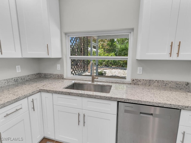 kitchen with dishwasher, white cabinets, and sink