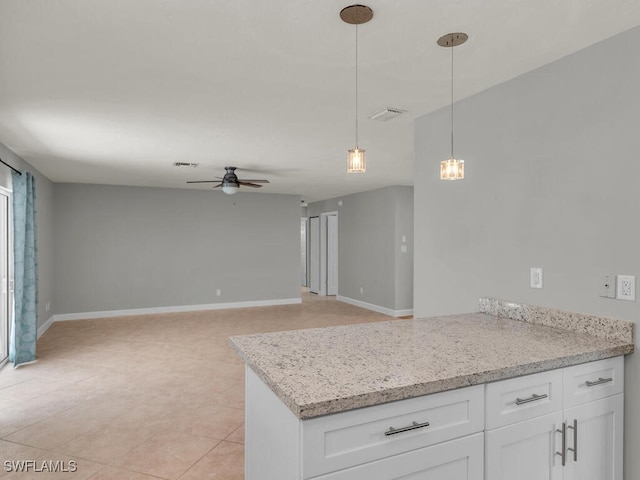 kitchen featuring light stone counters, ceiling fan, pendant lighting, light tile patterned floors, and white cabinetry