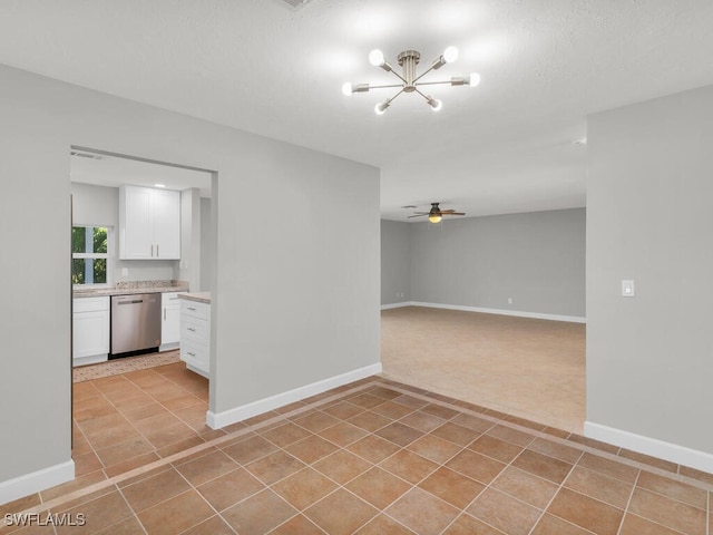 tiled spare room featuring ceiling fan with notable chandelier