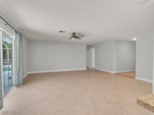 tiled spare room featuring ceiling fan