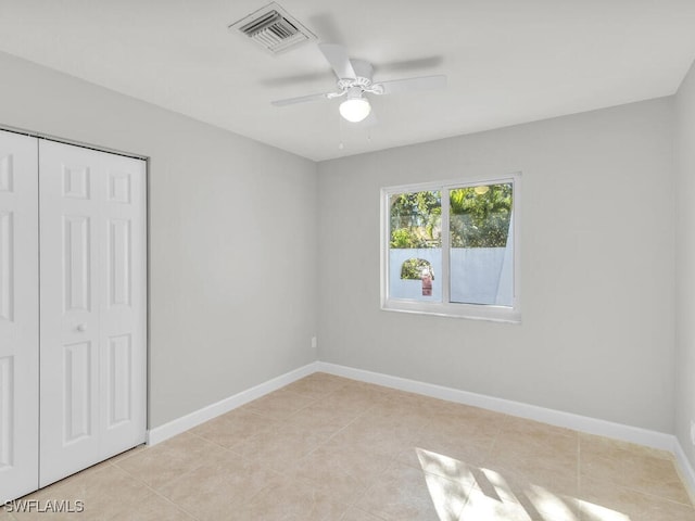 unfurnished bedroom featuring light tile patterned floors, a closet, and ceiling fan