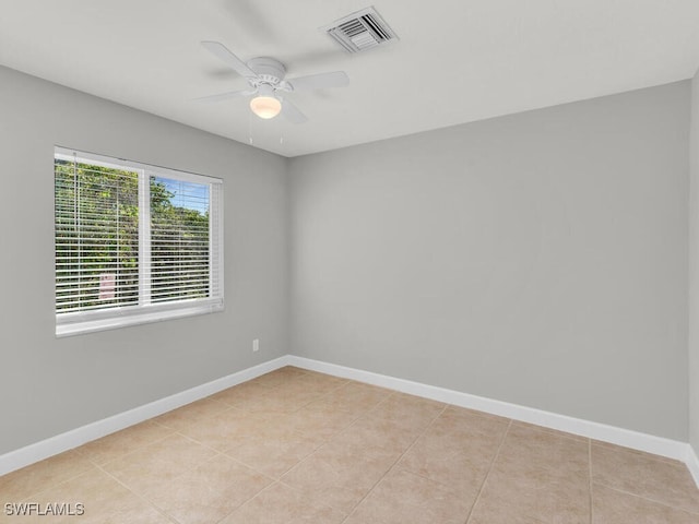 tiled spare room with ceiling fan