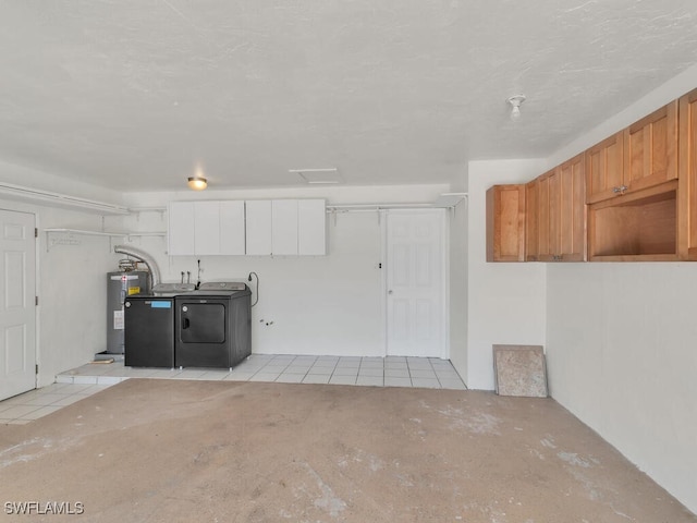 garage featuring electric water heater and separate washer and dryer