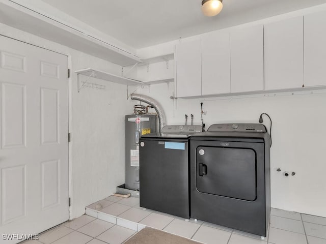 clothes washing area with washer and dryer, light tile patterned floors, electric water heater, and cabinets